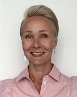 Valokuvassa vaalea lyhyttukkainen nainen hymyilee. 