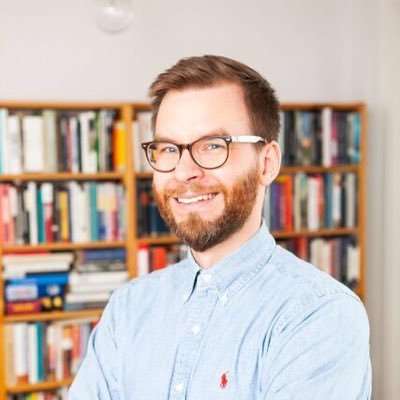 Antti kirjahylly takanaan. 