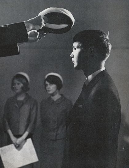 Vanha mustavalkoinen kuva jossa lukiolainen saa valkolakin.