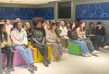 Opiskelijoita istumassa tuoleilla.