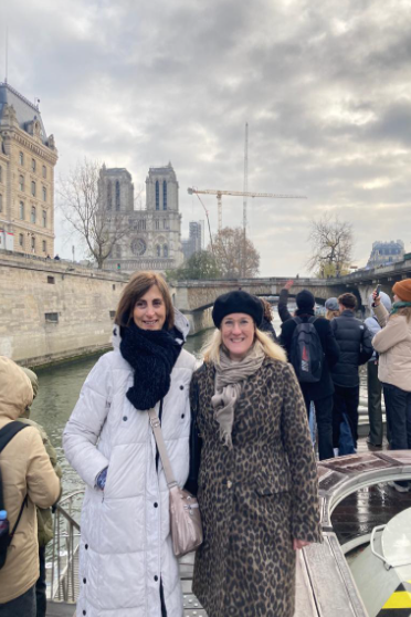 Kaksi opettajaa hymyilemässä kameralle jokiristeilyllä.