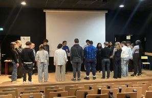 Opiskelijoita näyttämön lavalla.