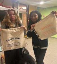 Kaksi opiskelijaa näyttämässä kangaskasseja.