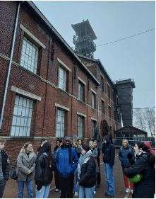 Ihmisiä vanhan tiilirakennuksen edessä.