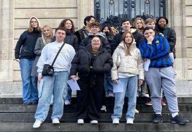 Opiskelijoita portailla rakennuksen edessä.