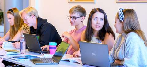 Opiskelijat istuva tietokoneiden ääressä. 