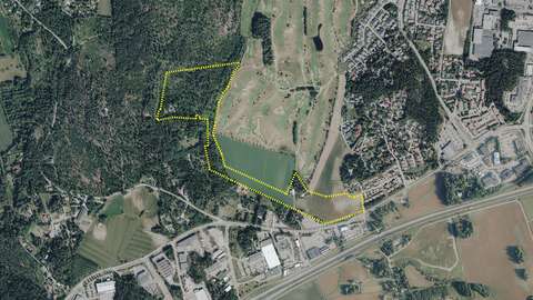 Metsäinen ja peltojen ympäröimä alue, johon piirretty aluerajaus.