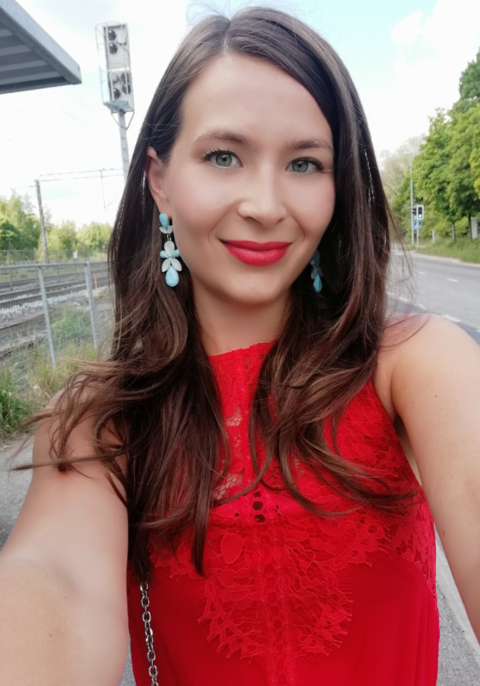 Sonja ottaa selfietä punaisessa mekossa. 