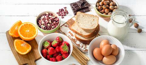 Pöydällä mahdollisia ruoka-allergeeneja: maitoa, hedelmiä, kananmunia ja pähkinöitä