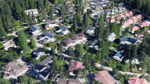 Ett landskap av täta punkter med byggnader, gator och träd som ser ut som ett flygfotografi.