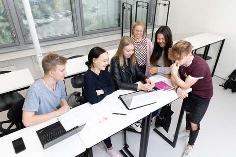 Opiskelijoita ja opettaja luokassa.