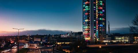 Öinen maisema Leppävaarassa. Oikealla korkea kerrostalo, joka on valaistu värikkäästi.