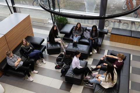 Opiskelijoita aulassa.