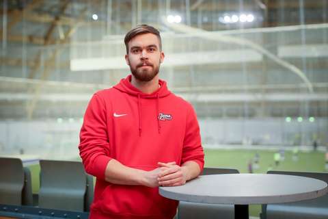 Antti seisoo punainen huppari päällä. 