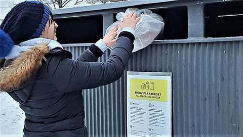 Woman recycling plastic.