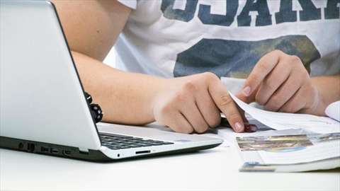 Henkilö tietokoneen ääressä.