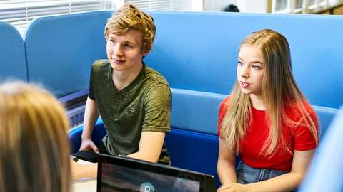 Lukiolaiset istuvat haastattelussa, haastattelija on tietokoneella. 