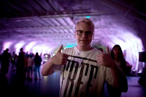 Nuori, iloinen mies hiphop-tapahtumassa.