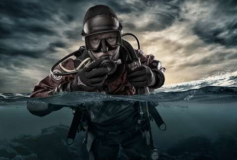 Ihminen sukelluspuvussa pinnan alla.