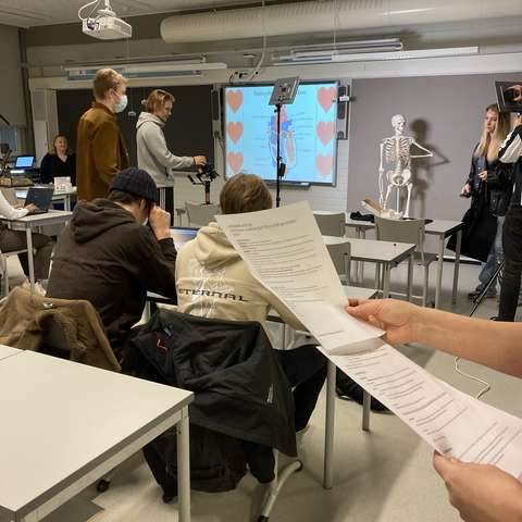 opiskelijoita kuvaustilanteessa biologian luokassa