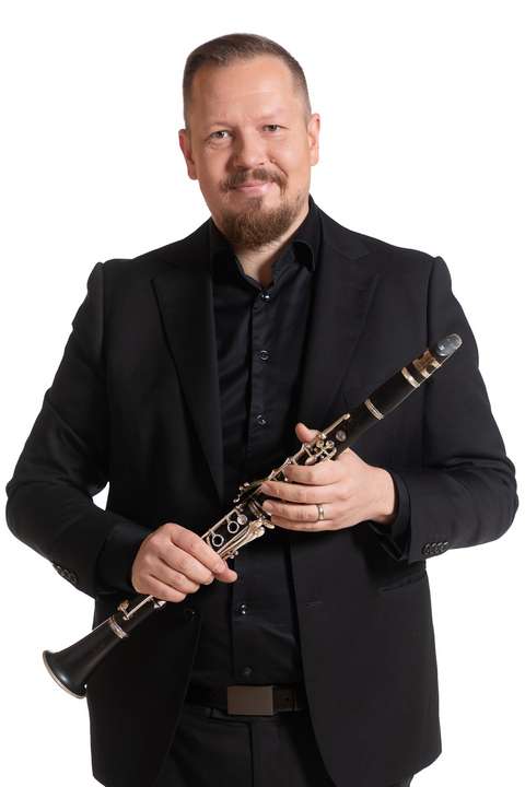 Klarinettspelaren håller klarinetten i sina händer.