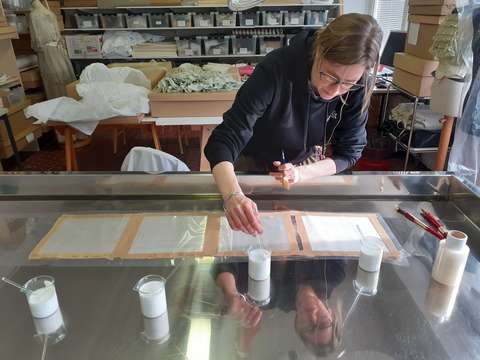 Nainen liimaa kangaskappaleita.