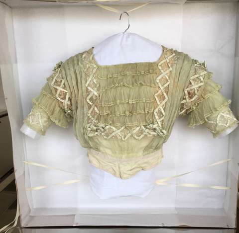 Vanhan naisten vihreän leningin yläosa säilytyslaatikossa.