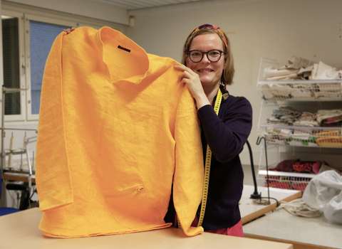 Yrittäjä Anita Penttinen esittelee ompelemaansa paitaa.