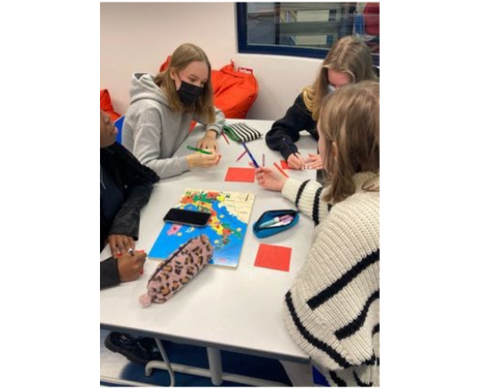 Espoonlahden lukion opiskelijoita pöydän äärellä askartelemassa kortteja.