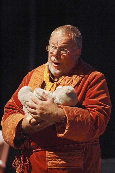 Färgfilmbild av en man som håller i en plyschleksak.