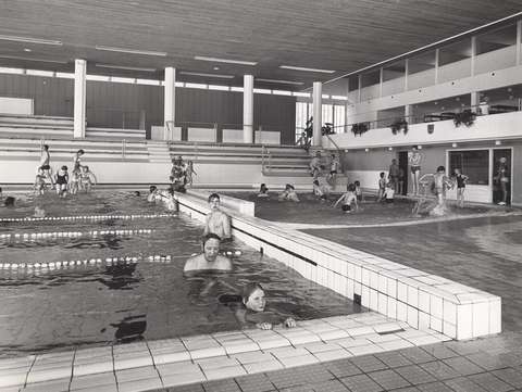 Tapiolan uimahalli. Mustavalkoinen sisäkuva pääaltaasta ja lastenaltaasta kovassa käytössä.