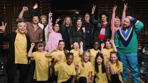 Sunan koulun kuoron oppilaat ja opettaja sekä Vain elämää artistit poseeraavat kameralle kahdessa rivissä.