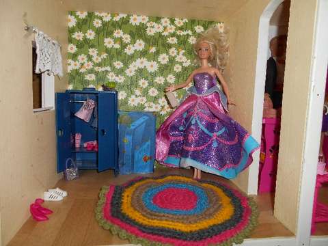 Barbie-nukke nukkekodin sisällä