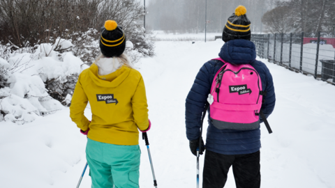 Kaksi sauvakävelijää talvisessa maisemassa.