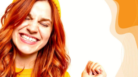 Lähikuva iloisen nuoren naisen kasvoista.