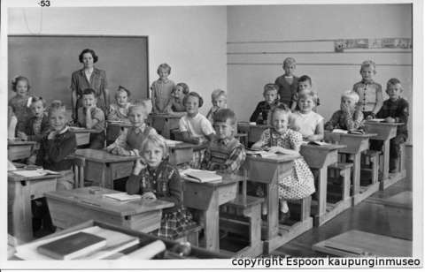 Kansakoululuokka pulpeteissaan. Mustavalkokuva.