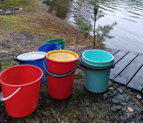 Useita ämpäreitä laiturin vierressä veden äärellä.