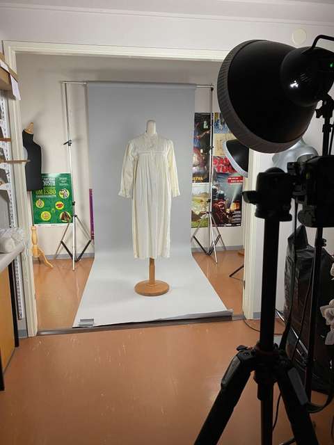 Studiokuvaustilanne jossa mekko torson päällä kuvattavana.