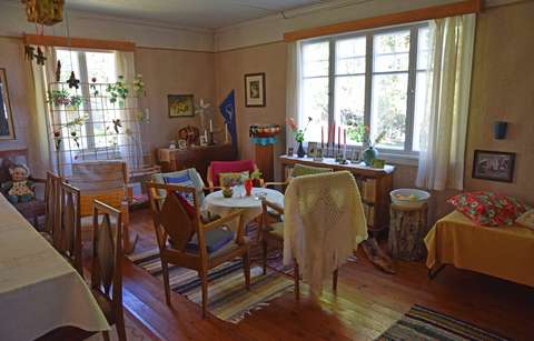 Talon interiöörikuva jossa pöytä, tuoleja, lipasto, sohva ja sänky.