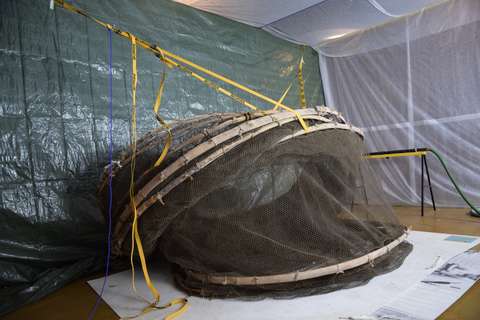 Rysän puhdistusta varten rakennettu teltta, jossa rysä on lattialla rengasosat tuettuna naruilla katosta roikkuen.