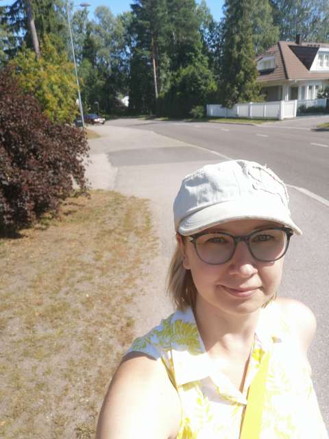 Tyttö lippalakki päässään ottaa selfien.