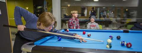 Nuoria pelaamassa biljardia. 