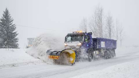 Kuorma-auto auraa lumea tieltä.