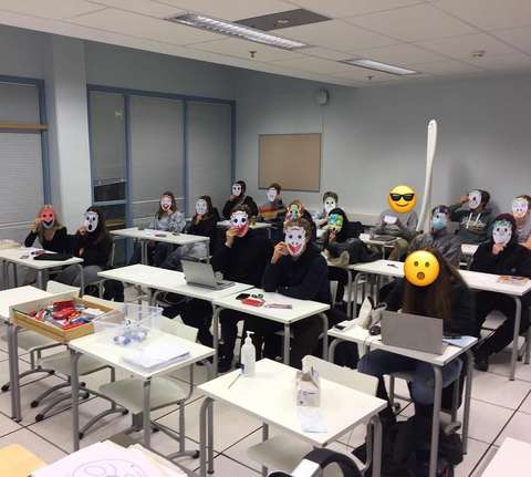 Opiskelijat istuvat luokassa maskit naamalla.