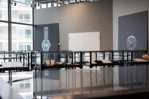 Vitriinejä museotilassa. Seinällä kaksi suurikokoista kuvaa kelloista.