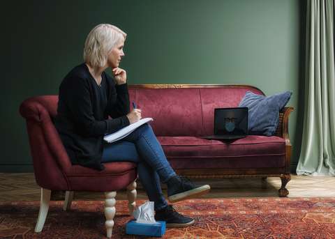 Henkilö istumassa sohvalla.