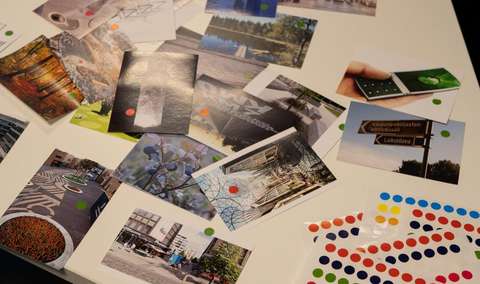 Kuvassa kuvakortteja, joihin liimattu punaisia ja vihreitä tarroja.