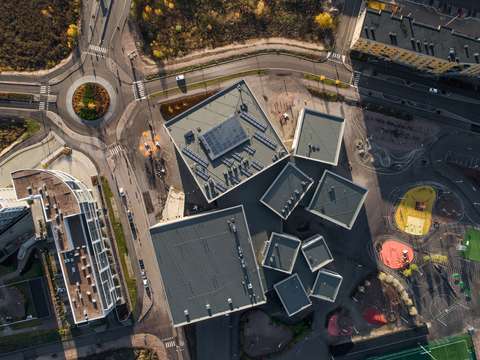 A roundabout depicted from a bird's eye view with adjoining apartment buildings and a playground.