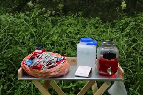 Glowes, water and juice on the table.