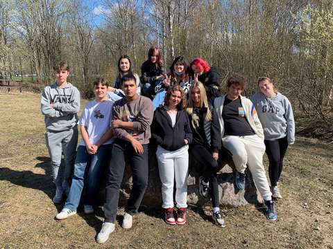 Opiskelijaryhmä seisoo nurmikolla.